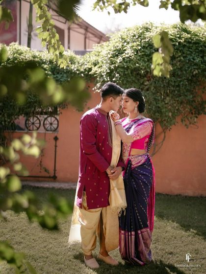 An intimate portrait of the couple in a garden, framed by leaves, creating a natural and private feel.