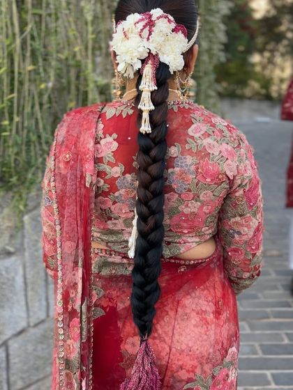 A close up of the traditional braid with a large floral headpiece, showing the intricate details of the flower arrangement and jewellery.