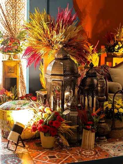 A cozy corner featuring antique-style lanterns and colorful dried grasses. This setup adds warmth and a touch of rustic charm to the overall decor.