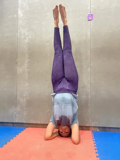 A client holds a steady headstand, a great exercise for building core strength, balance, and focus. We incorporate new challenges every day.