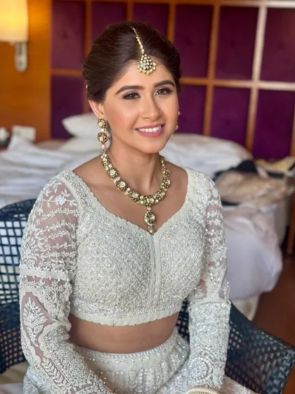 A happy bride ready for her ceremony, showcasing a classic updo that is both beautiful and practical for a long day of celebrations.