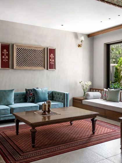 The main living area is a comfortable and inviting space, with a plush sofa, a traditional Indian rug, and curated wall art.