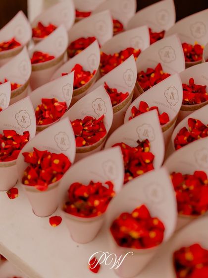 Cones of red rose petals, ready for guests to shower the couple during their wedding ceremony. Elegance is in every detail.
