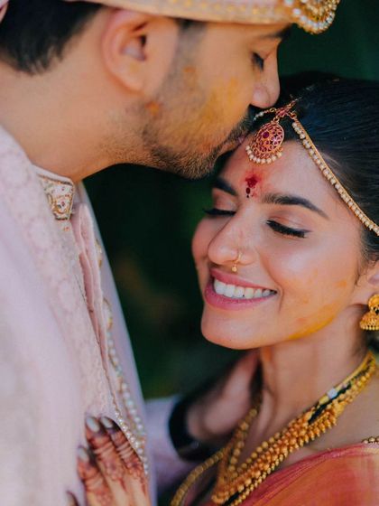 A tender forehead kiss, a classic and romantic shot that beautifully captures the love between the couple.