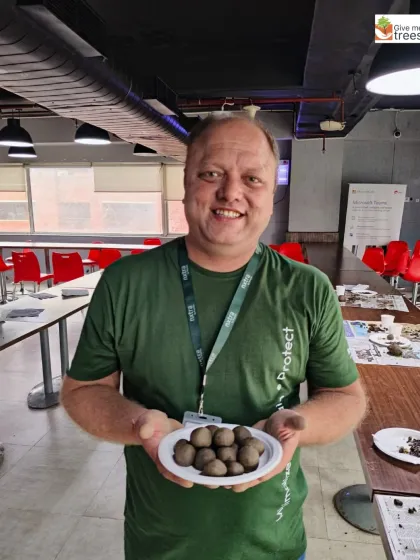 A proud participant from Amdocs/Nxtra with his finished seed balls. These will be scattered in barren areas to grow into native plants and trees.