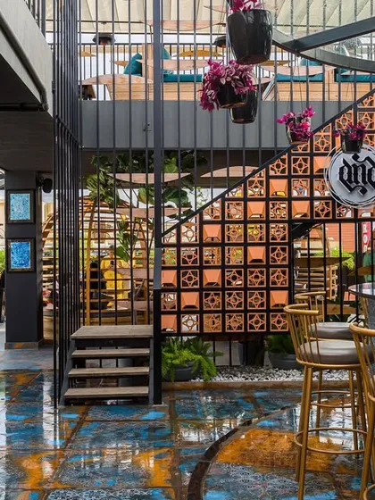 The bar area at 'Highdrate' is a feast for the eyes, with a pop-art mural, custom flooring, and a terracotta block staircase. Every element is designed to contribute to a high-energy, artistic atmosphere.