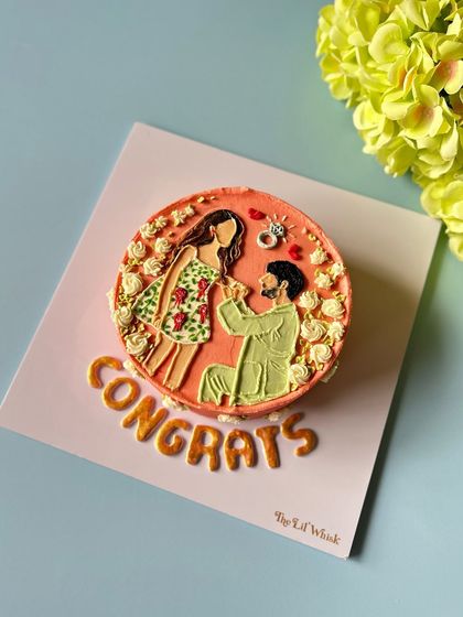 "Congrats." This adorable bento cake captures the moment of a proposal with a hand-piped illustration, making it the perfect way to celebrate an engagement.
