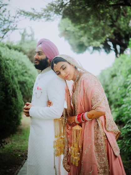 A serene and romantic portrait of the bride resting her head on her groom's shoulder. This shot, taken in a quiet garden, is full of gentle emotion.