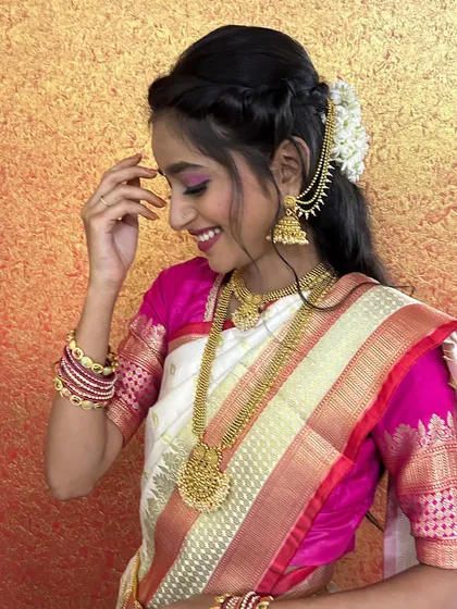 A happy and candid shot, showing the bride's joyful expression. The hairstyle is a simple yet elegant braid with fresh flowers.