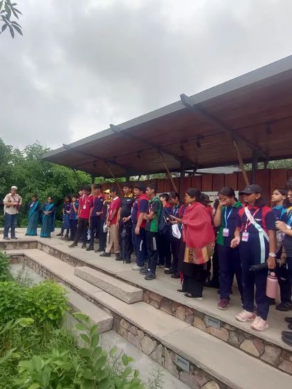 Students from VIBGYOR High listen intently during a nature walk at Aravalli Biodiversity Park, learning about ecological restoration and native plant species.