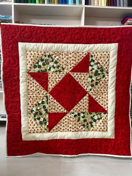 This beginner baby quilt features a classic star pattern in red and green, a perfect first project for learning fundamental piecing techniques.