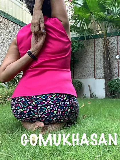 A close-up of the hand clasp behind the back in Gomukhasana, a sign of open shoulders.