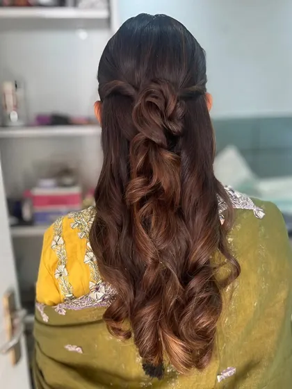 A beautiful and intricate half-updo with a knotted and braided detail.