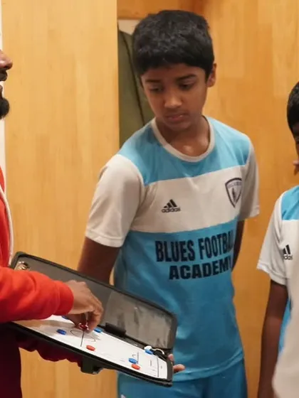 It all starts with a plan. Our licensed coach uses a tactics board to explain positional play to our youth team before a match. We focus on developing intelligent players who understand the game on a deeper level.