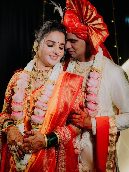 A close-up of the couple surrounded by their varmala garlands, a symbol of their union. The warmth and love between them are palpable.