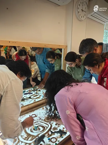 Parents get hands-on with the same sensory materials their children use. This shared exploration at the light table fosters empathy and gives parents a direct window into the power of play-based learning.