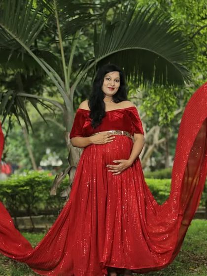 The off-shoulder design and sparkling sequin fabric of this red flying gown make it a glamorous choice for a maternity photoshoot. The long trail adds that extra touch of drama for stunning pictures.