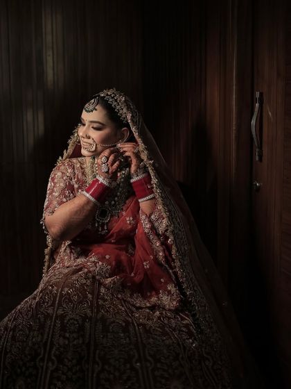 A dramatic and artistic shot of my bride. The moody lighting highlights the flawless makeup and the intricate details of her bridal jewellery and outfit.