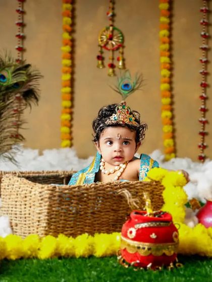 A peek-a-boo moment with our little Krishna. This Janmashtami setup with a basket and colorful props is perfect for capturing playful shots.