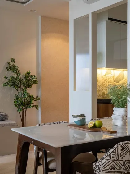 An unseen shot from 'House in the Hills', showing the dining table with a view into the kitchen. The open-plan design creates a sense of connection between the spaces.