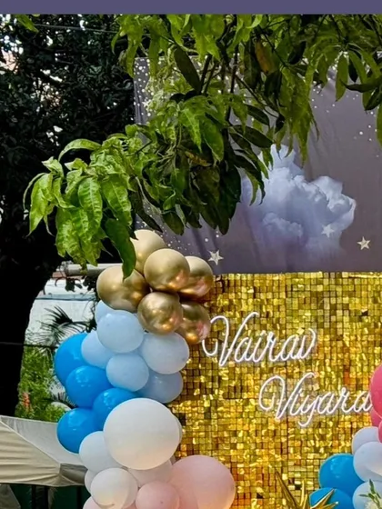 A detail of the gold sequin wall with the twins' names in a lovely script font, adding a personalized touch to the sparkling backdrop.