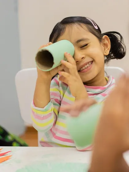Another shot of a child finding fun in simple craft materials, a testament to our belief in imaginative, resource-rich play.