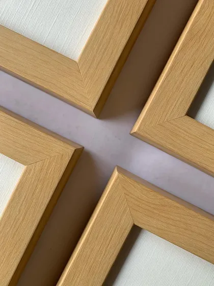 A shot of the four corners of the maple frames meeting, demonstrating how they can be arranged in a tight grid for a clean, organized gallery wall.
