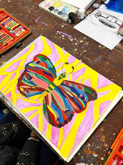 A stunning, colorful butterfly painted with bold patterns and a vibrant background, showing a student's excellent grasp of color and composition.