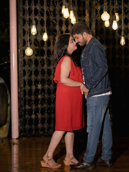 An intimate moment between a couple, with the hanging bulbs of our rustic gate set creating a moody and romantic atmosphere.