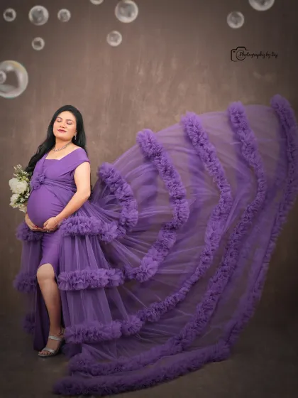 A glamorous studio portrait with a flying purple ruffled gown and bubble effects for a fun, magical touch.