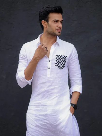 A close-up of the white linen kurta with the checkered pocket. The texture of the fabric and the unique detail are clearly visible.