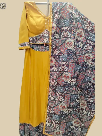 This view showcases the full yellow lehenga set with its intricately printed dupatta, offering a complete look at this festive ensemble.
