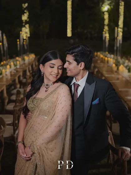 A close-up, romantic shot of the couple at their reception. The soft lighting and elegant table setting provide the perfect backdrop.