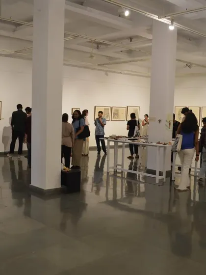 A wide view of the gallery during the preview of 'Bring me Flowers', showing visitors spread throughout the space.