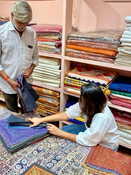 On a sourcing trip, selecting handcrafted textiles with a local artisan. I love diving into piles of colorful fabrics, each with its own unique pattern and story. These are the elements that bring texture, culture, and personality into a home.
