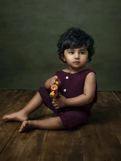 A sweet toddler session, capturing that curious age between 8 and 12 months. The simple wooden floor and green backdrop keep the focus on his adorable expression.