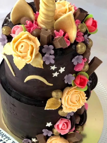 A unique chocolate unicorn cake, combining a popular theme with rich chocolate ganache and colorful buttercream flowers.