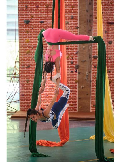 Teamwork makes the dream work! Here, two of our talented instructors demonstrate a beautiful and complex doubles pose on the silks.