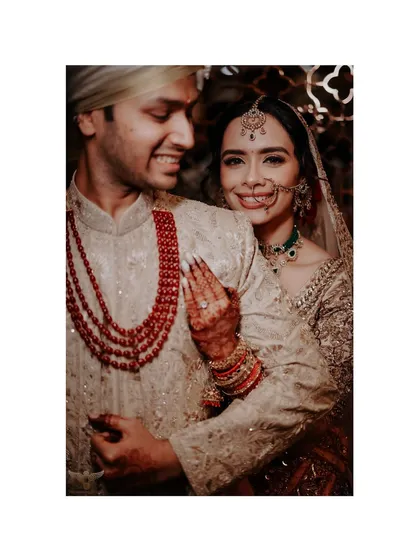 The warmth of an embrace. This candid shot captures the bride's joyful smile as she hugs her groom from behind, a moment of pure happiness and affection.