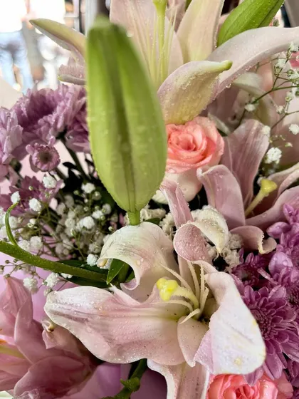 A beautiful lily bud about to bloom, surrounded by fresh roses and chrysanthemums. I love using a mix of flowers to create bouquets with texture and life.