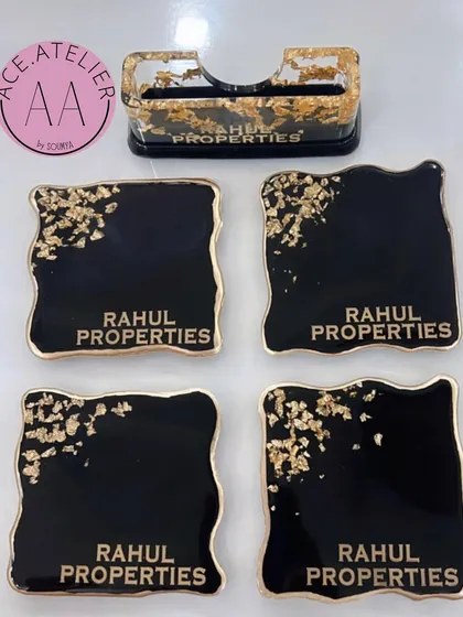 Here is an example of a sophisticated corporate gift set I created. This black and gold theme includes four personalized coasters and a matching cardholder, all featuring the company's name, "Rahul Properties," for a professional and lasting impression.