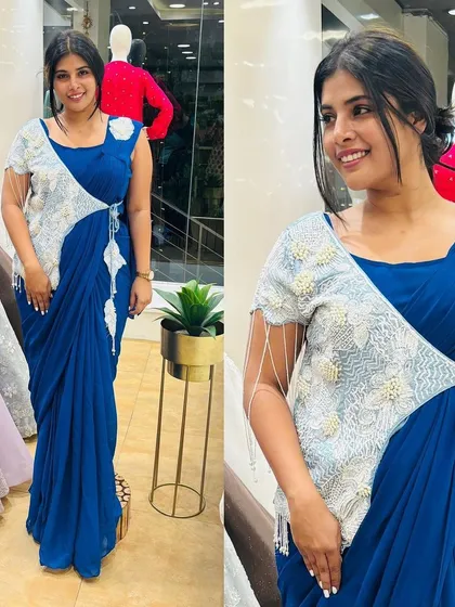 A beautiful royal blue draped saree featuring an asymmetric embroidered panel. The delicate pearl tassels on the shoulder add a touch of elegance to this unique Indo-Western design.