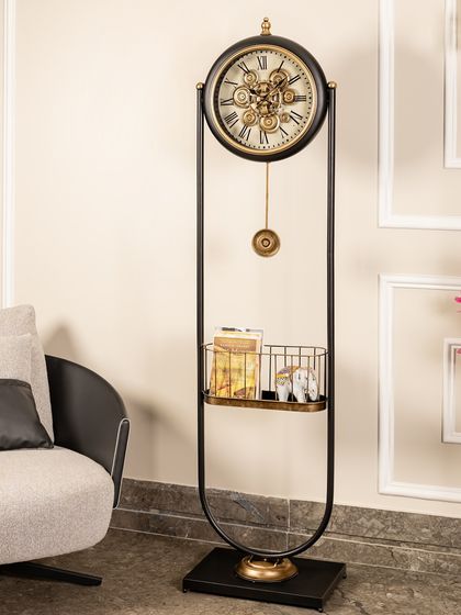 This standing clock features a unique U-shaped frame in black and gold. The mesmerizing moving gears and a built-in shelf for small decor items make it both a functional timepiece and a focal point.