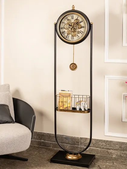 This standing clock features a unique U-shaped frame in black and gold. The mesmerizing moving gears and a built-in shelf for small decor items make it both a functional timepiece and a focal point.