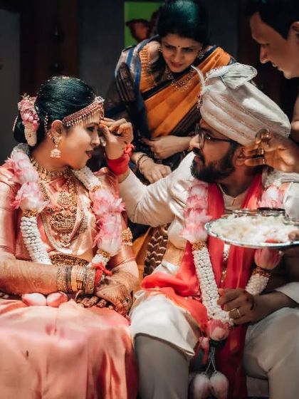 A key moment in a South Indian wedding ceremony, with the groom applying sindoor to the bride's forehead.