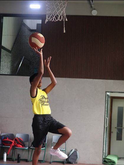 A player practices a layup. Repetition is key to mastering the fundamental scoring techniques of basketball.