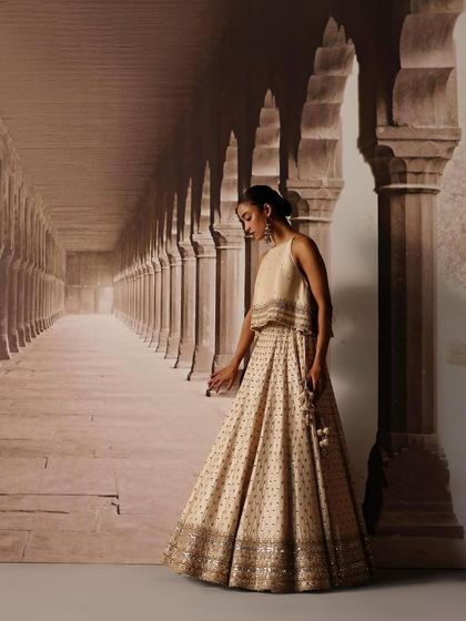 A model styled in a simple yet elegant crop top and lehenga set. The focus here is on the clean lines and intricate border detailing, perfect for a minimalist bride or bridesmaid.
