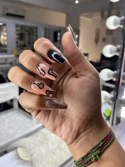 A bold and edgy design in a coffin shape. This set features a nude base with black and glitter flame-like swirls, creating a dynamic and eye-catching effect.