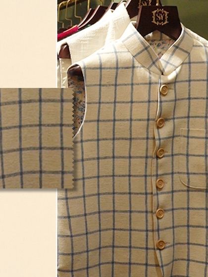 Feel the richness of texture that redefines luxury. A close-up of a checked linen Nehru vest, with a swatch to emphasize the quality of the weave.