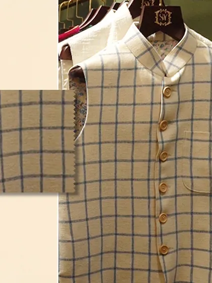 Feel the richness of texture that redefines luxury. A close-up of a checked linen Nehru vest, with a swatch to emphasize the quality of the weave.